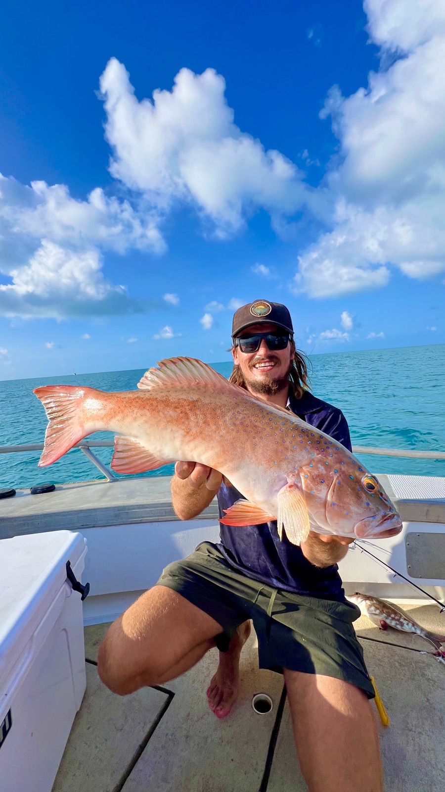 Angler holding a coral trout on an offshore reef charter off Darwin