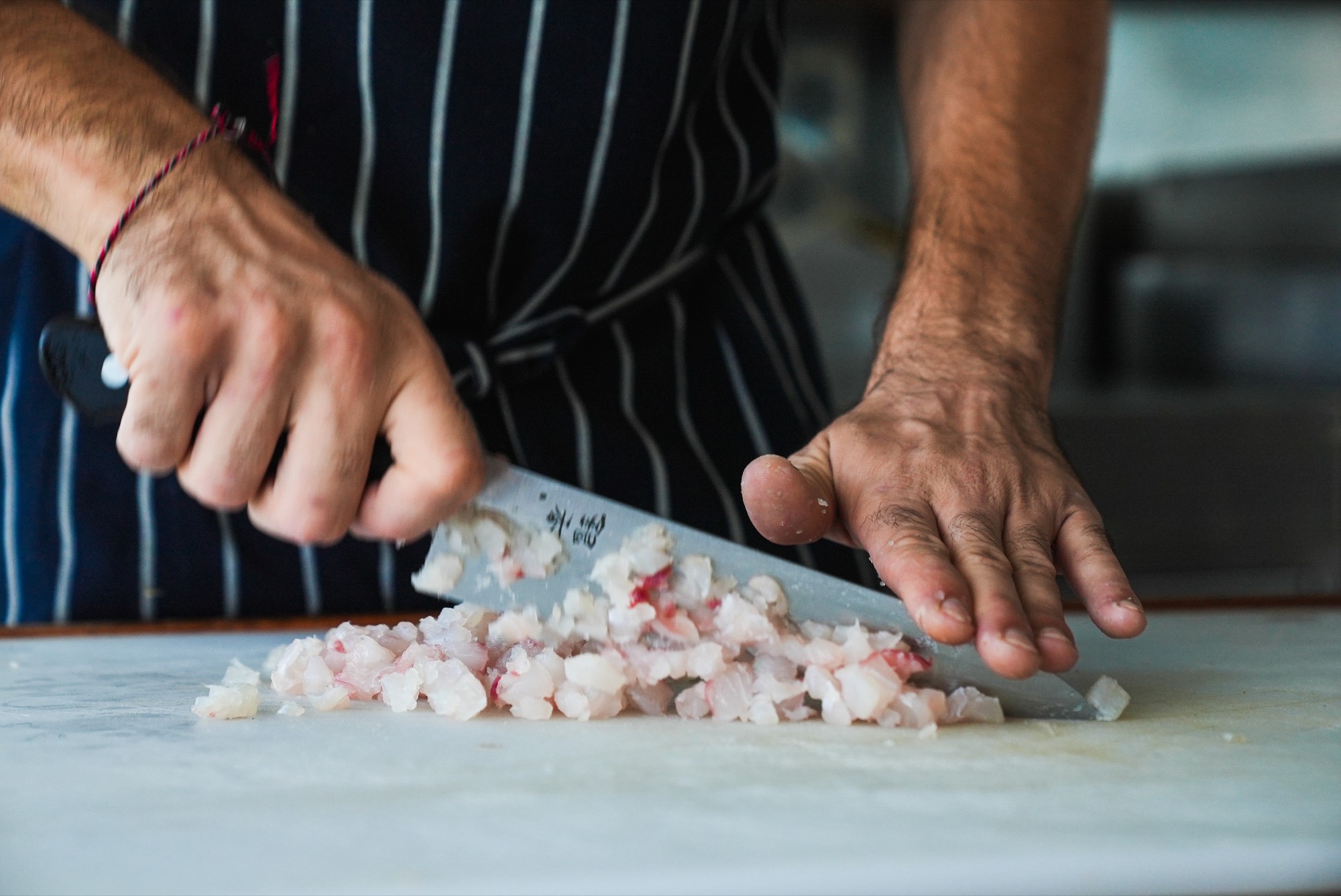 Chef dicing freshly caught fish for a Catch, Cook and Cruise