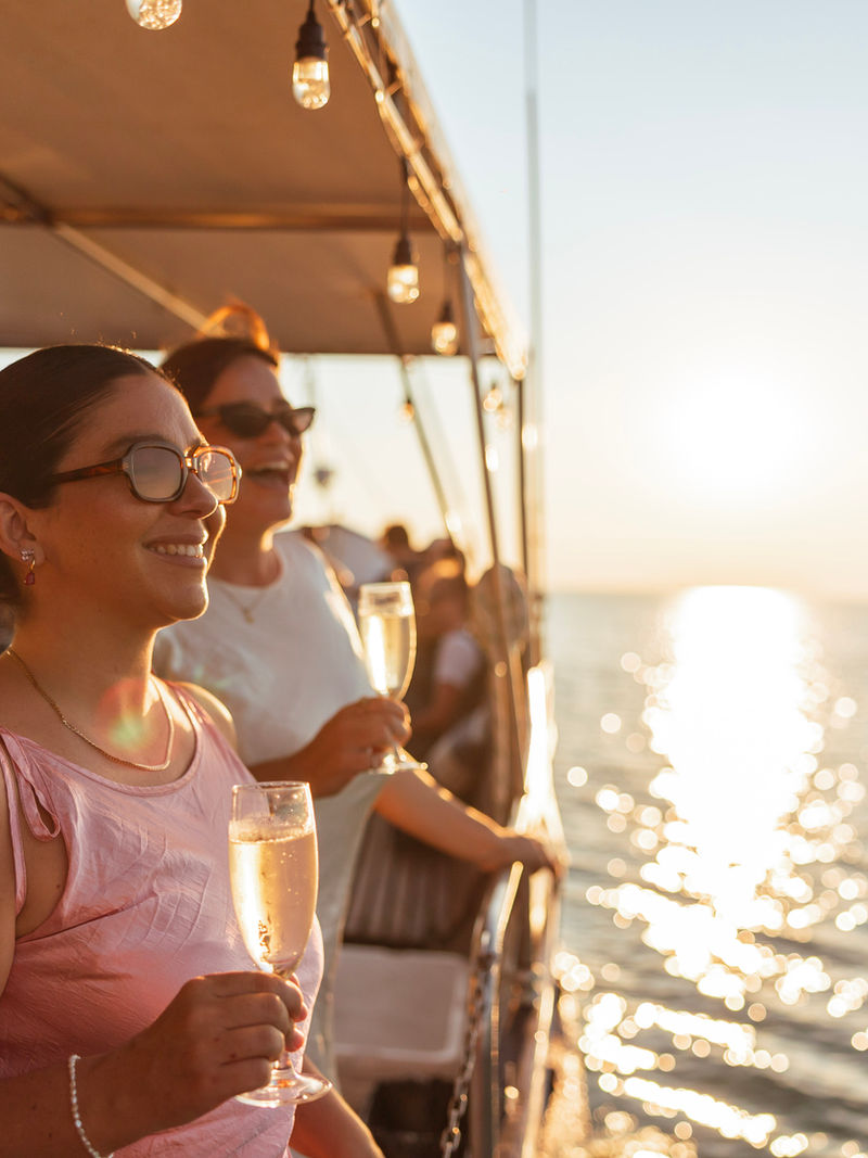 Two guests with champagne at sunset on a Cape Adieu dinner cruise, Darwin Harbour