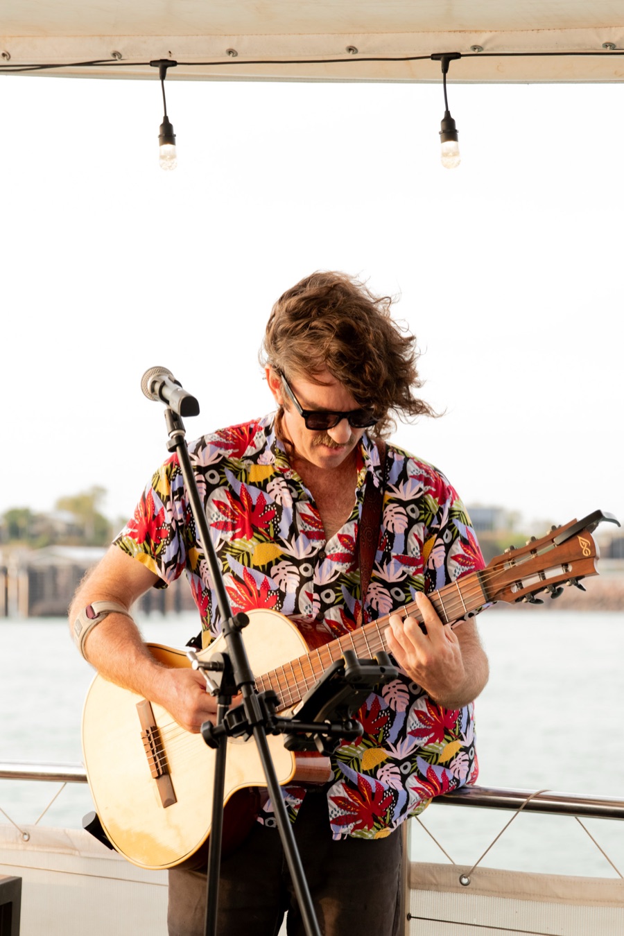 A guitarist performing live on deck during a Cape Adieu Darwin Harbour corporate cruise