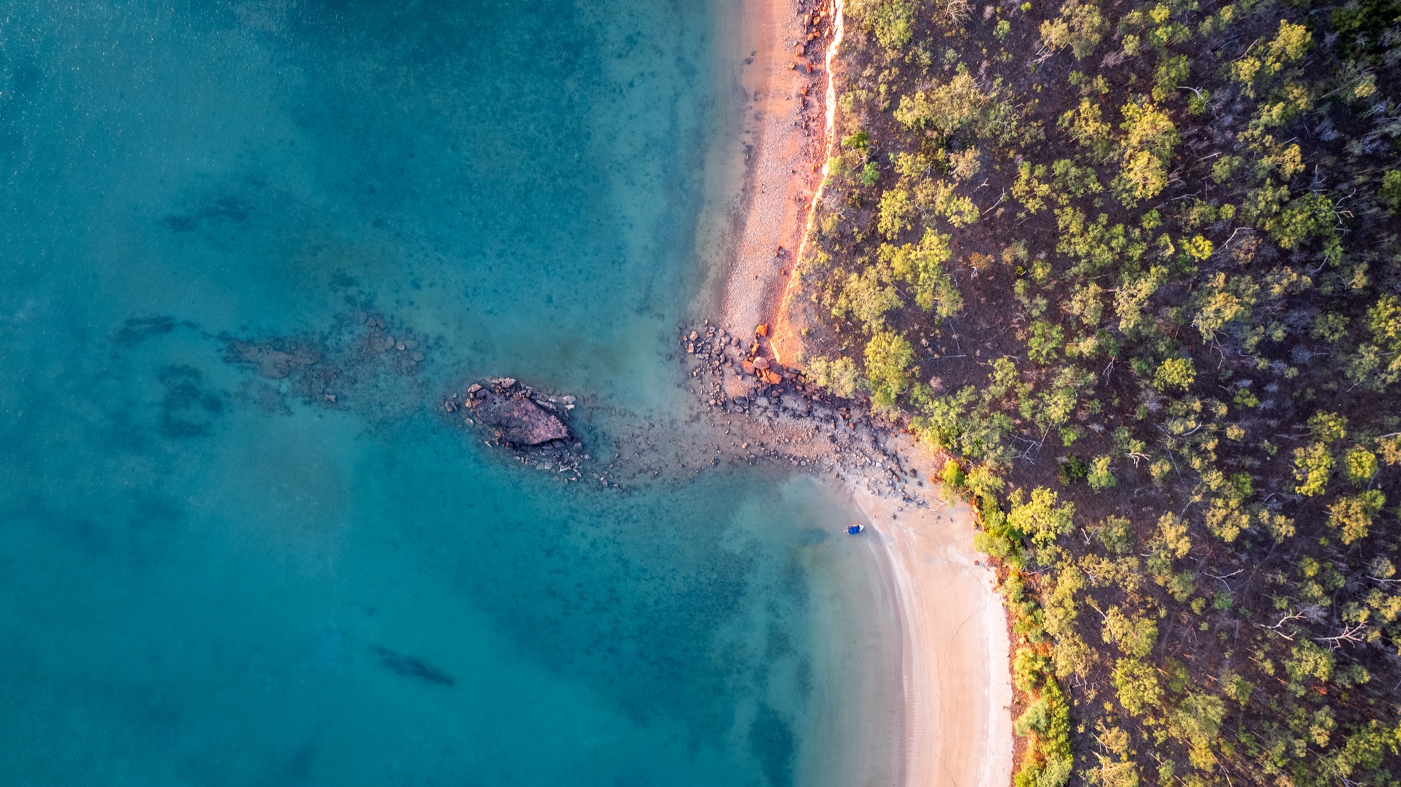 Aerial of a hidden white-sand cove on a remote Top End safari coastline