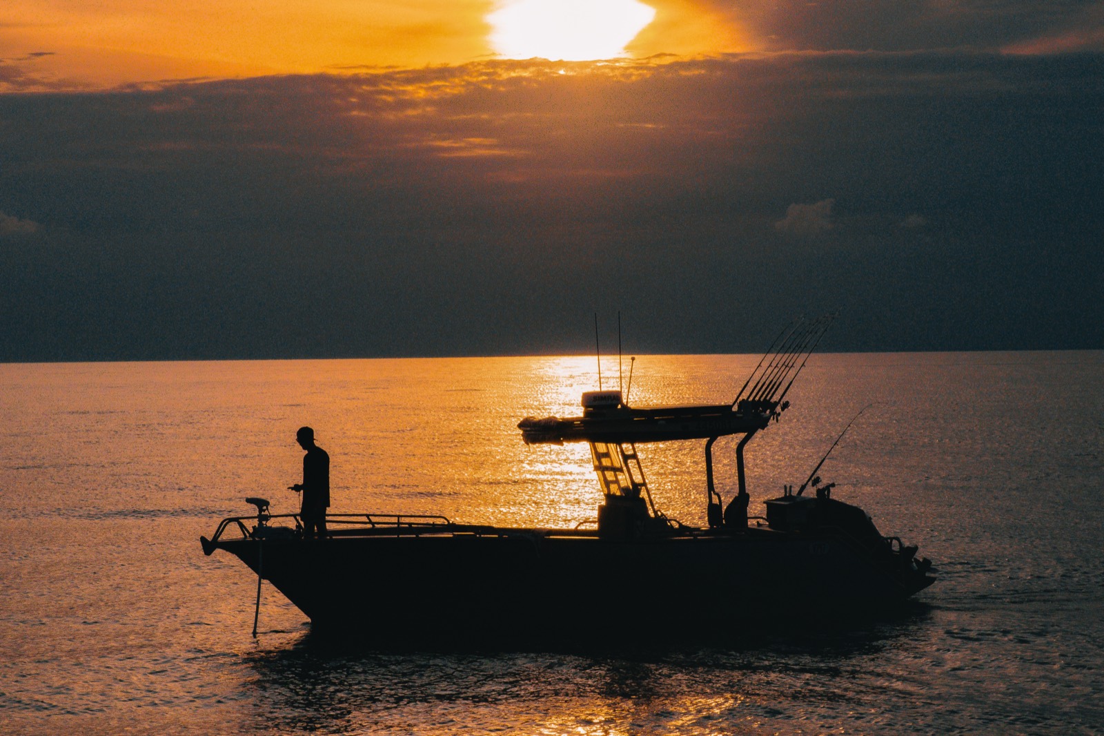 Skipper aboard the Salty Brumby silhouetted against a Top End sunset offshore from Darwin